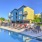 a pool with chairs and tables by it and buildings around it